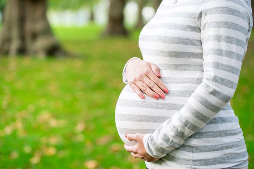 Happy and young pregnant woman in park in summer La Cour de cassation et les enfants nés par GPA