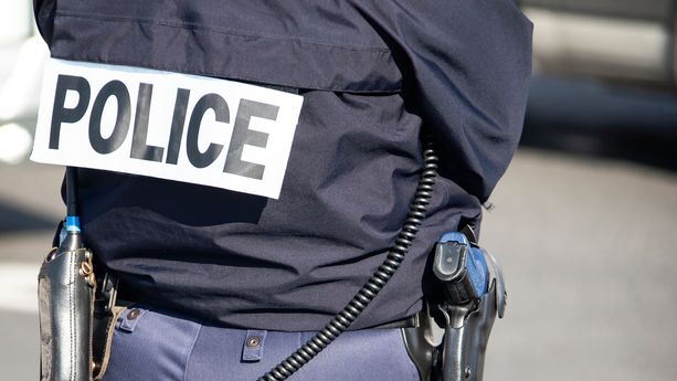 The back of the police officer with the inscription "POLICE" with a gun and a walkie-talkie. Découverte macabre au Grau-du-Roi : un adolescent avoue le meurtre