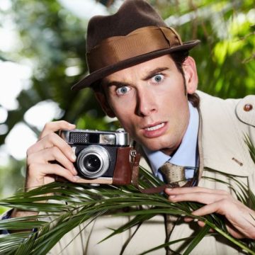 Retro spy man, camera and jungle for investigation, inspection or journalist with shock at job. Private investigator, secret photographer and retro paparazzi in trees, bush or leaves for surveillance Une enquête pétillante dans ‘Les morts manquent de correction’