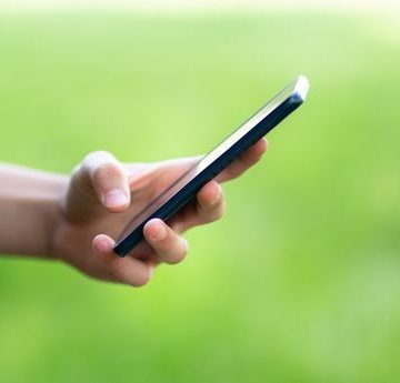Young teenager outside holding the phone stock photo Un homme inculpé pour violences sexuelles et diffusion d’images pédocriminelles en Finlande