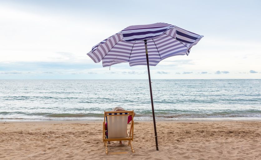 Traveler woman relax on the beach chair with umbrella at the beach. Les Vacances: Un Temps Existentiel et Révolutionnaire