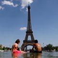 Un grimpeur escalade la tour Eiffel et accroche un drapeau américain