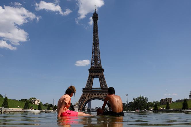 e775128f-b6cb-45e9-a420-7e9e302c536e Un grimpeur escalade la tour Eiffel et accroche un drapeau américain