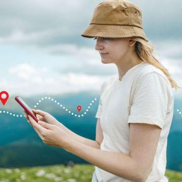 Success tourist woman searching right direction on smartphone on top of mountain with nature background. Mountain progression path. Applications pour randonneurs : une nouvelle manière de s’orienter