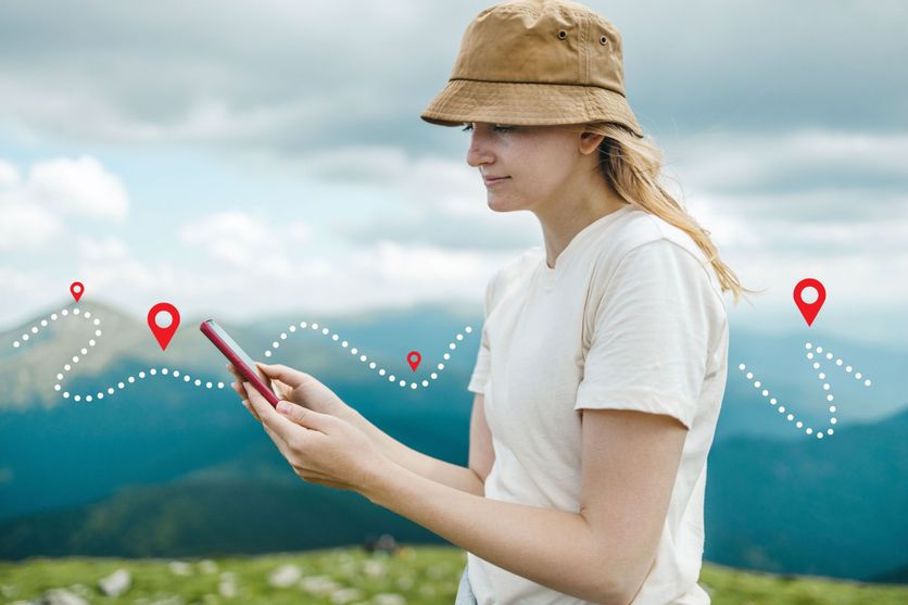 Success tourist woman searching right direction on smartphone on top of mountain with nature background. Mountain progression path. Applications pour randonneurs : une nouvelle manière de s’orienter