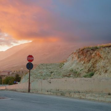 Serene sunset over mountain landscape with a stop sign and clouds Critique du roman « Une maison au Levant » de Carole Dagher
