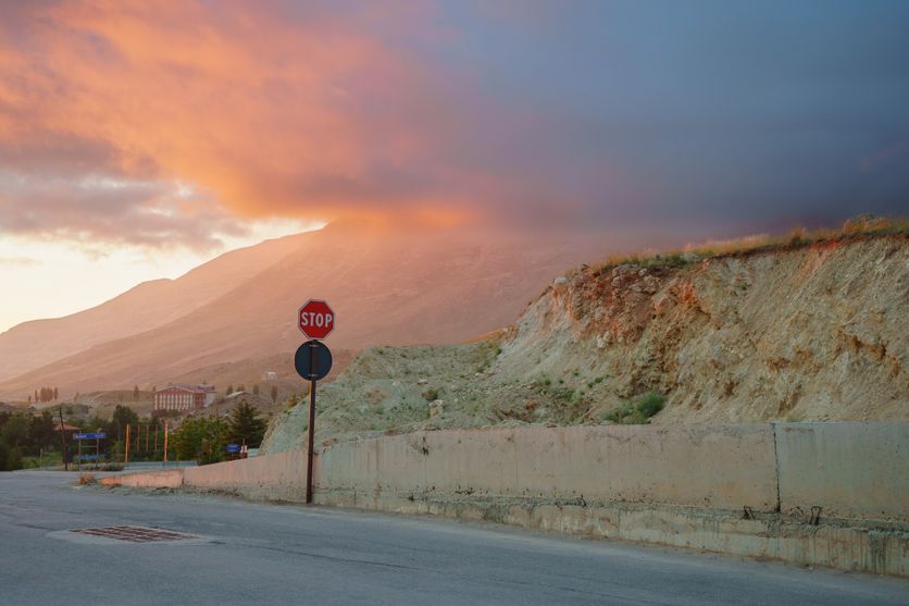 Serene sunset over mountain landscape with a stop sign and clouds Critique du roman « Une maison au Levant » de Carole Dagher