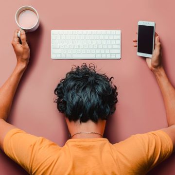 Flat lay man with burn out sleeps on table with keyboard,smartphone and coffee. Le stress au travail dans l’UE: Préoccupation des eurodéputés